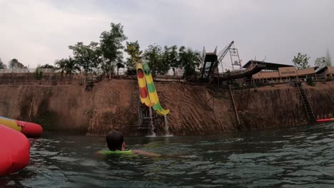 slowmotion of blond male going down a waterslide in thai waterpark