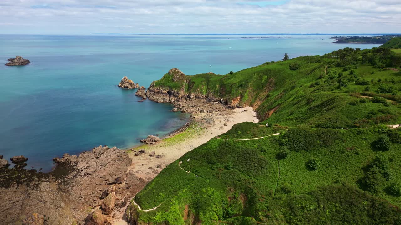 Gwin Zégal coastline in Brittany, cliffs, lush green hills, secluded sandy beach, turquoise water, France. Aerial forward