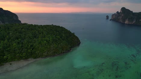 Unglaublicher-Luftbildflug-über-Eine-Tropische-Insel-Bei-Sonnenuntergang-Und-Bewölktem-Himmel-Mit-Booten,-Die-Auf-Einem-Türkisfarbenen-Meer-Segeln