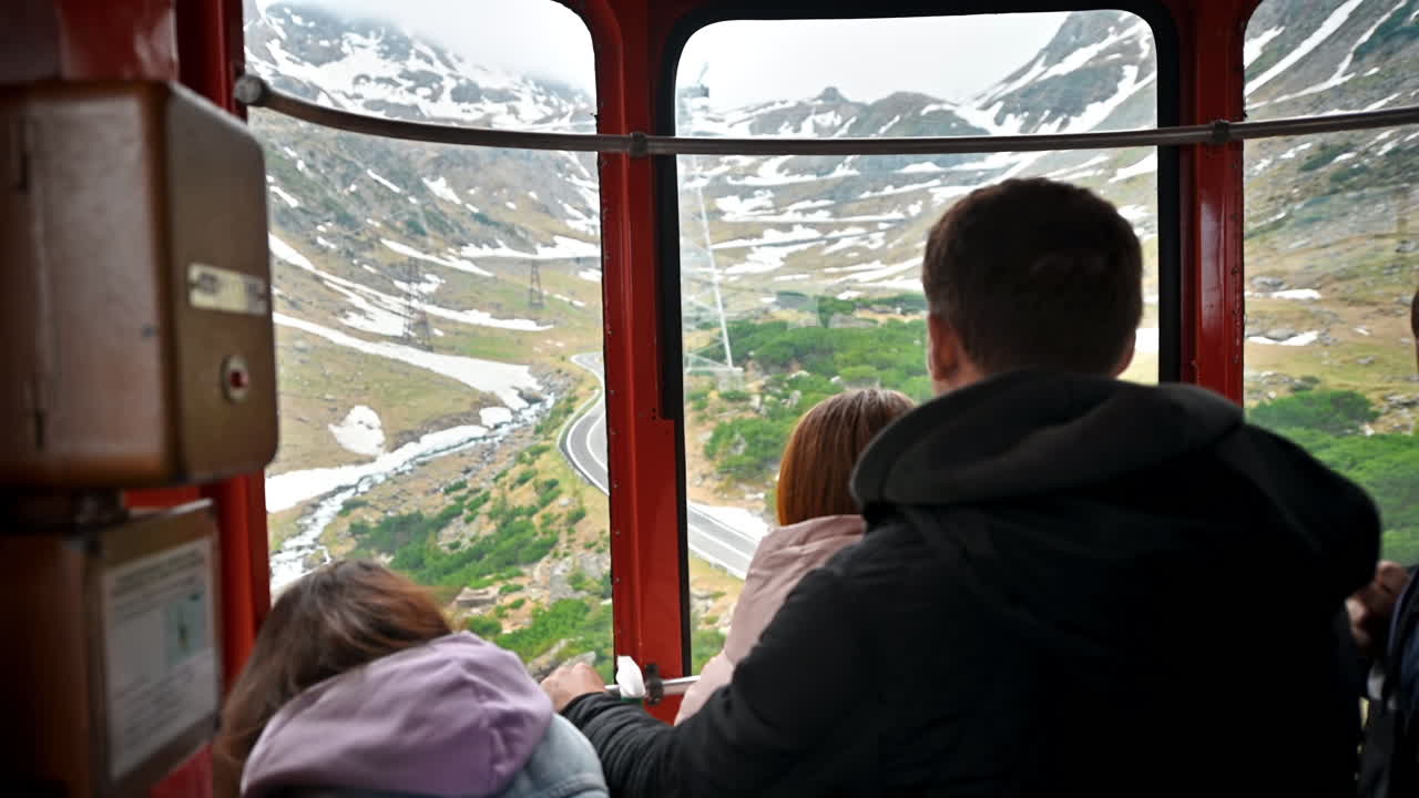 Näkymä köysiradasta sen sisältä huipulle menevällä vuorella, sisällä matkustajia. Transfăgărășan-reitti Karpaattien vuoristossa