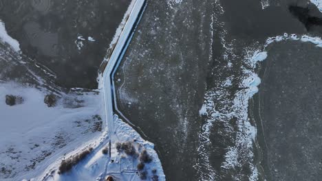 in winter, the vete cape pier leading to the curonian lagoon is covered with ice and snow on all sides