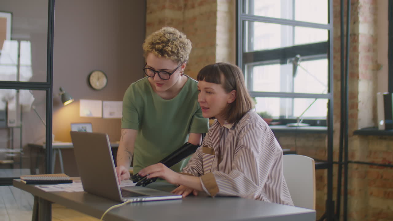 Woman with Prosthetic Arm Helping Colleague at Work in Office