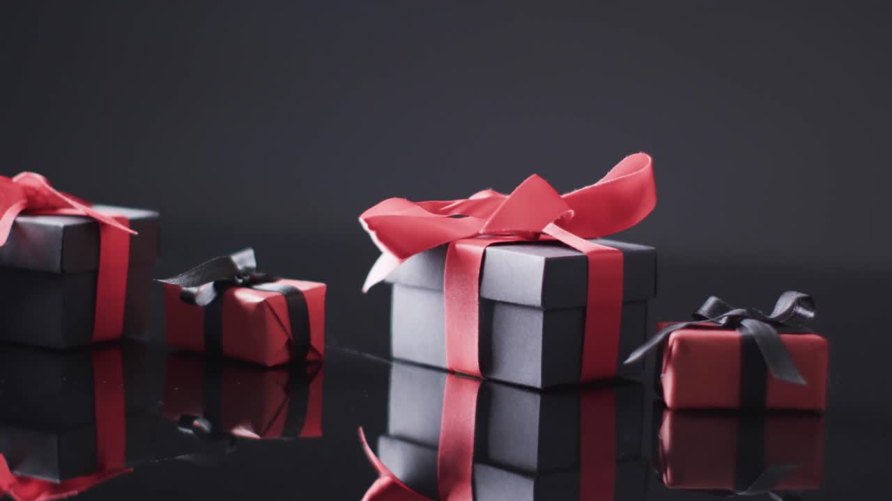 빨간색과 검은색 리본을 가진 선물 상자 및 검은색 배경에 대한 복사 공간의 비디오