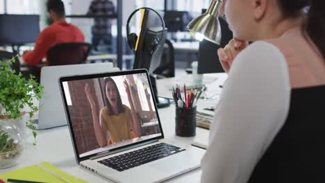 Kaukasische-Frau,-Die-Im-Büro-Einen-Videoanruf-Mit-Einer-Kollegin-Auf-Einem-Laptop-Führt