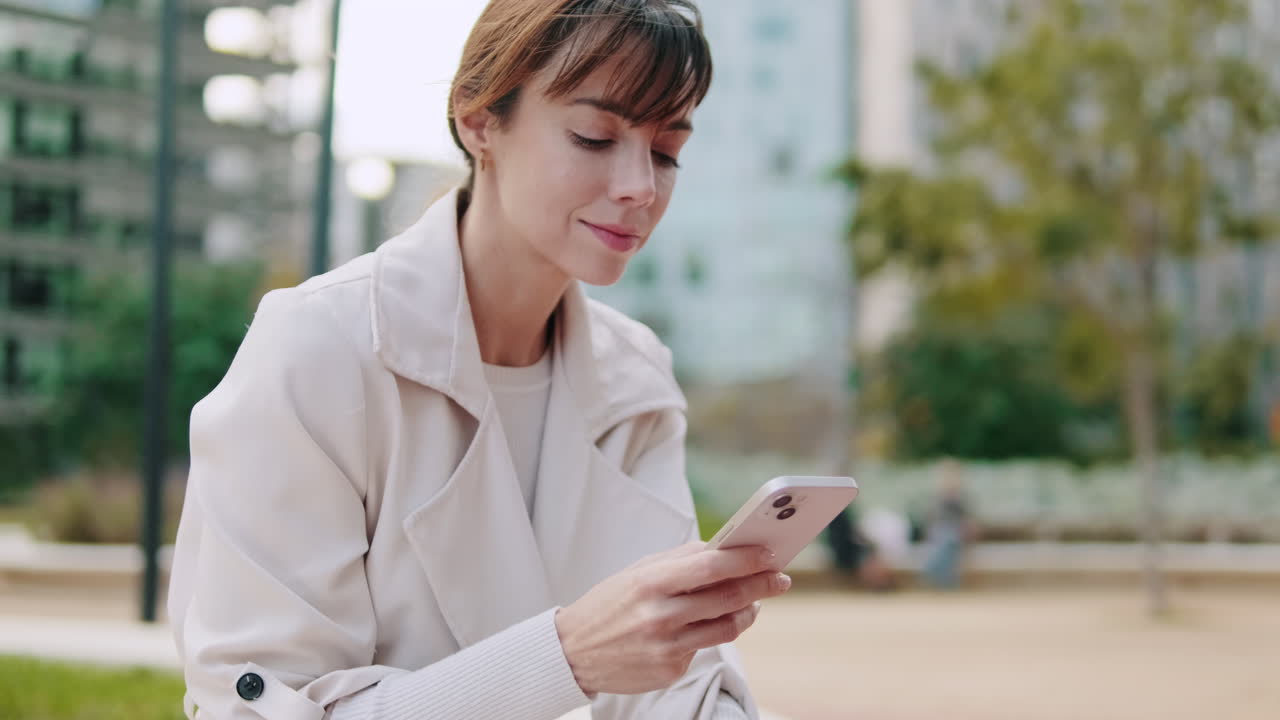 Young Woman Using Smartphone Outdoors in Urban Park