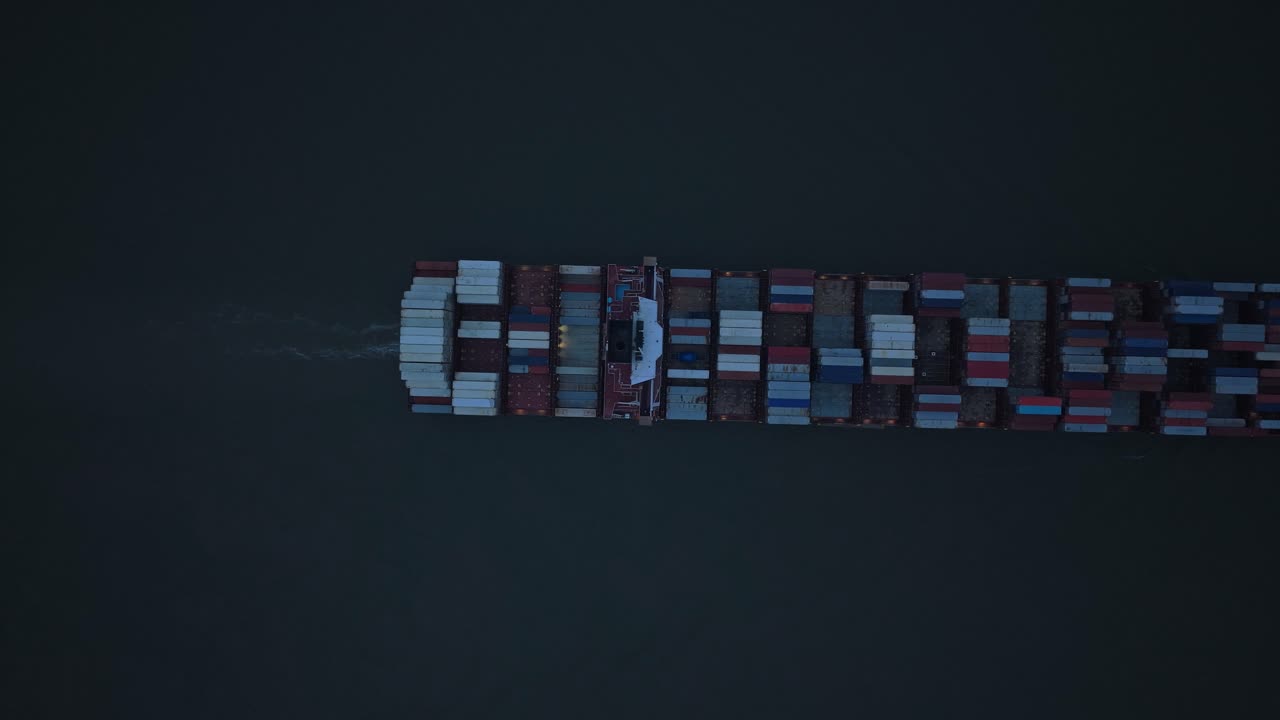 Flying over cargo liner on Elbe River at sunset, Germany freight transport