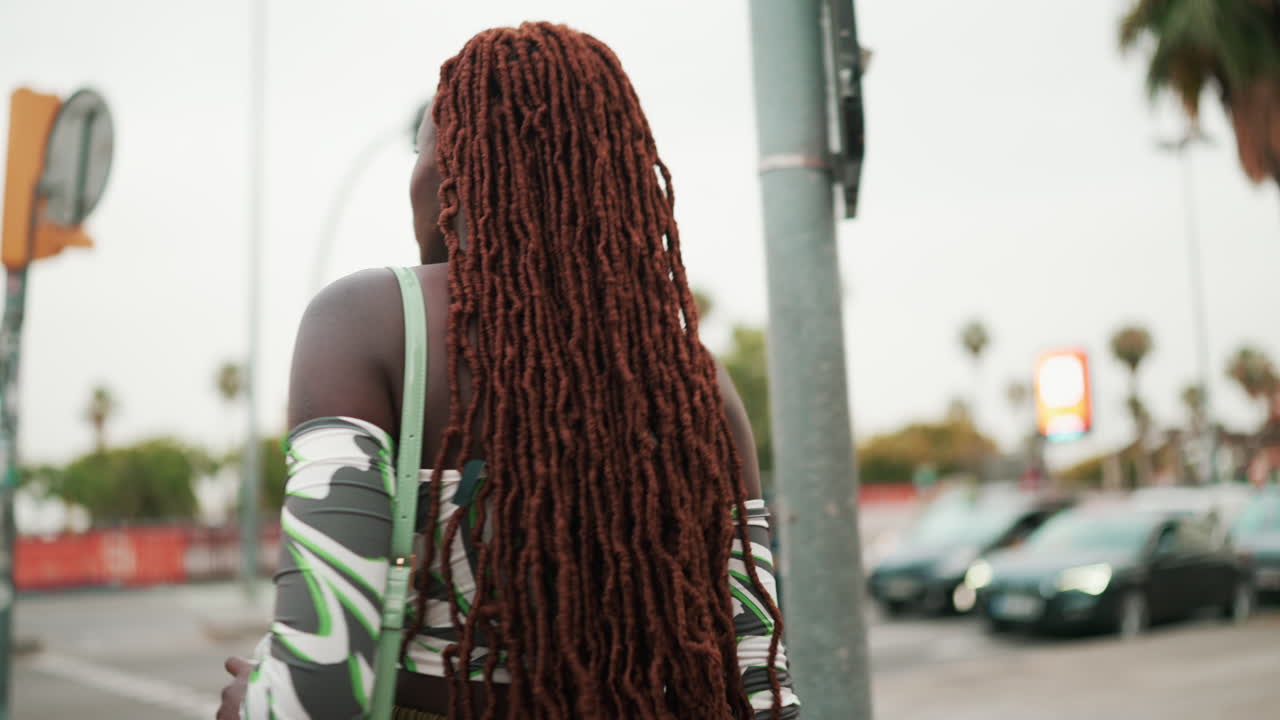 Donna con dreadlocks che attraversa la strada