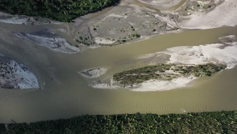 Aerial-sliding-over-a-dried-river-surrounded-by-spruce-forest-in-Alaska-in-summer