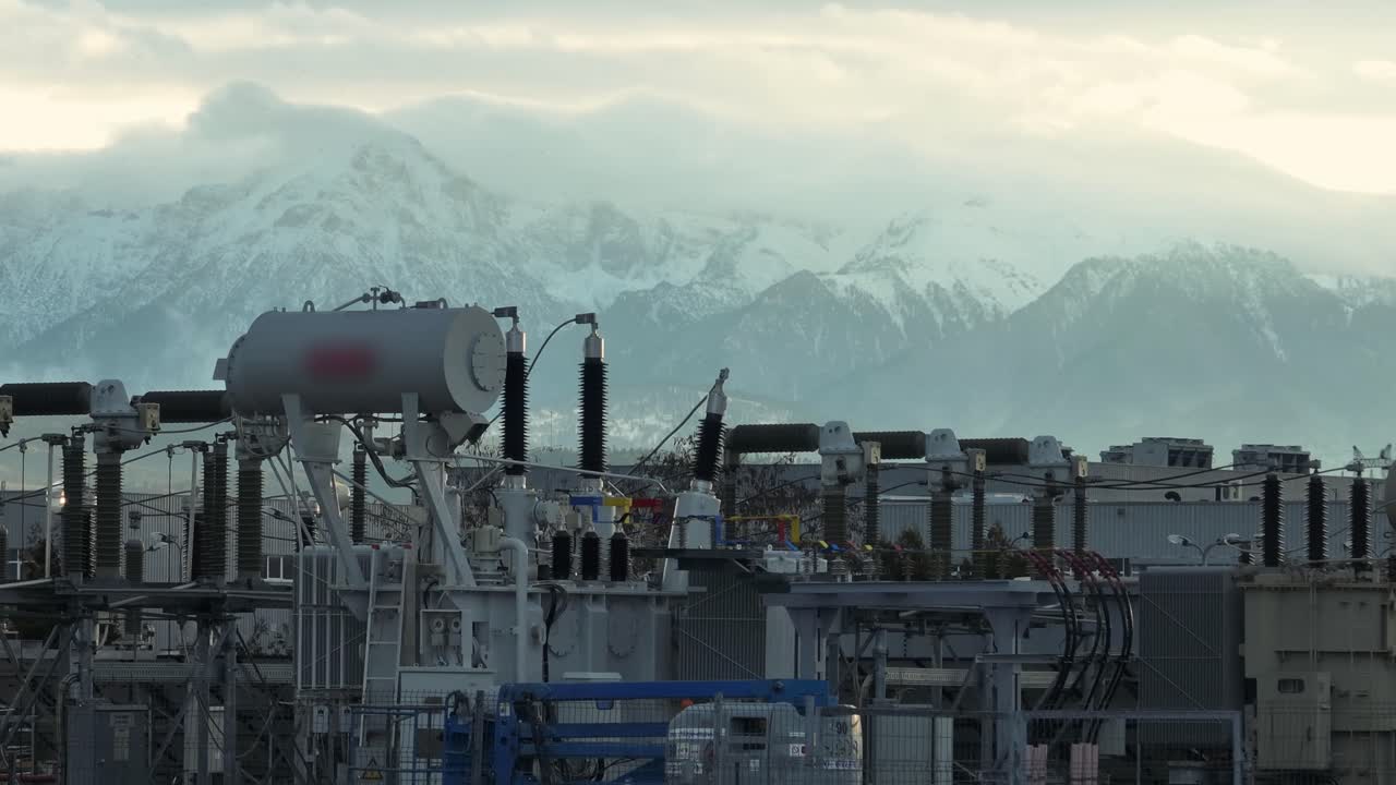 Power station with snowy mountain backdrop, industrial atmosphere