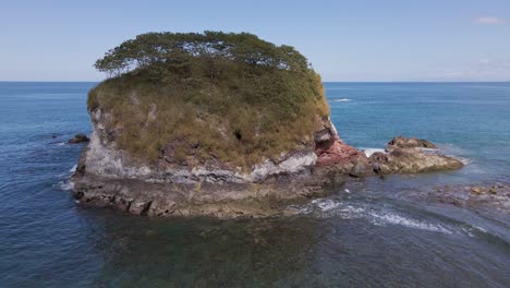 volando hacia y sobre una pequeña isla que revela mares abiertos y un hermoso horizonte