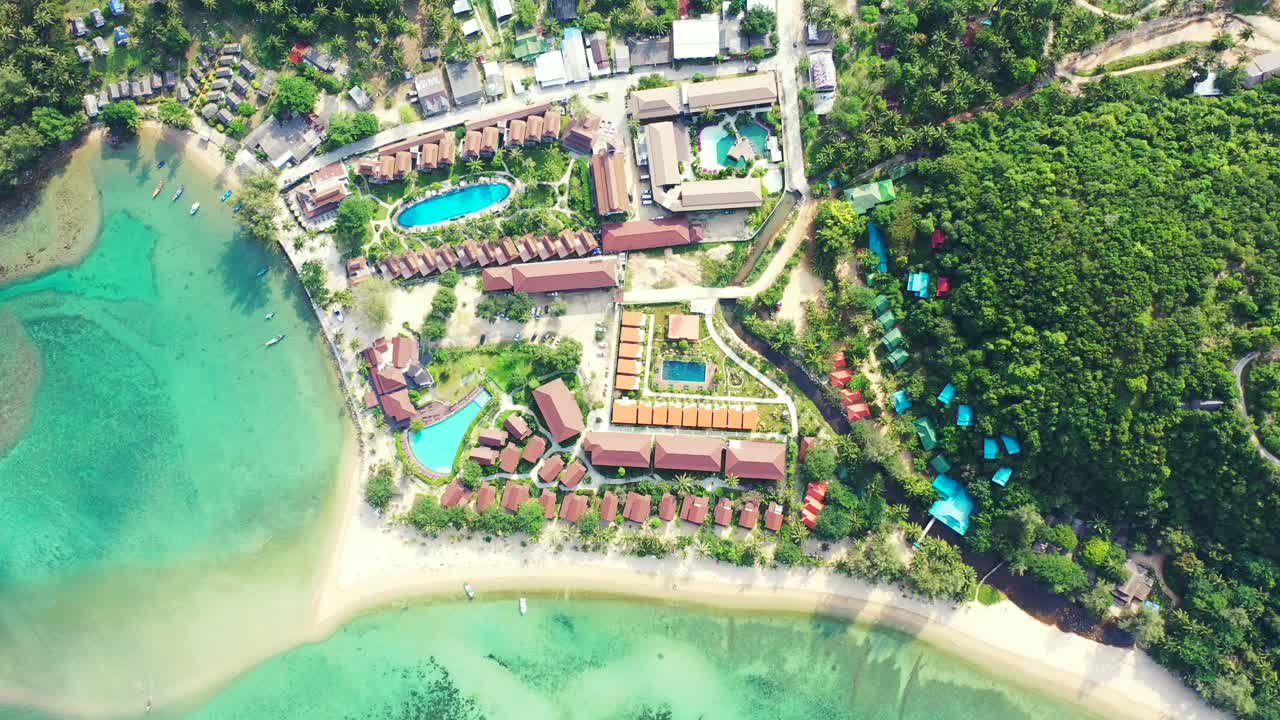 Beautiful tranquil vacation resort on shoreline of tropical island with white sandy beach and calm turquoise lagoon, Thailand