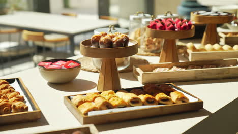 disfrutar de una lujosa mesa de pastelería en un hotel brunch con pasteles glamurosos y croissants hermosamente iluminados por el sol