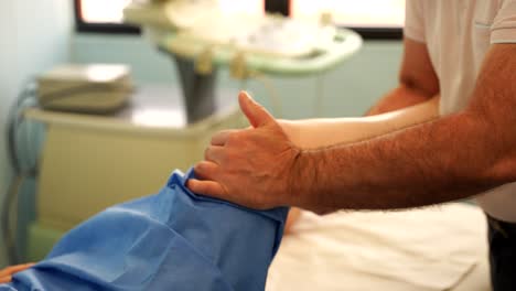 fisioterapeuta controlando la rodilla de un paciente en una oficina brillante, pan