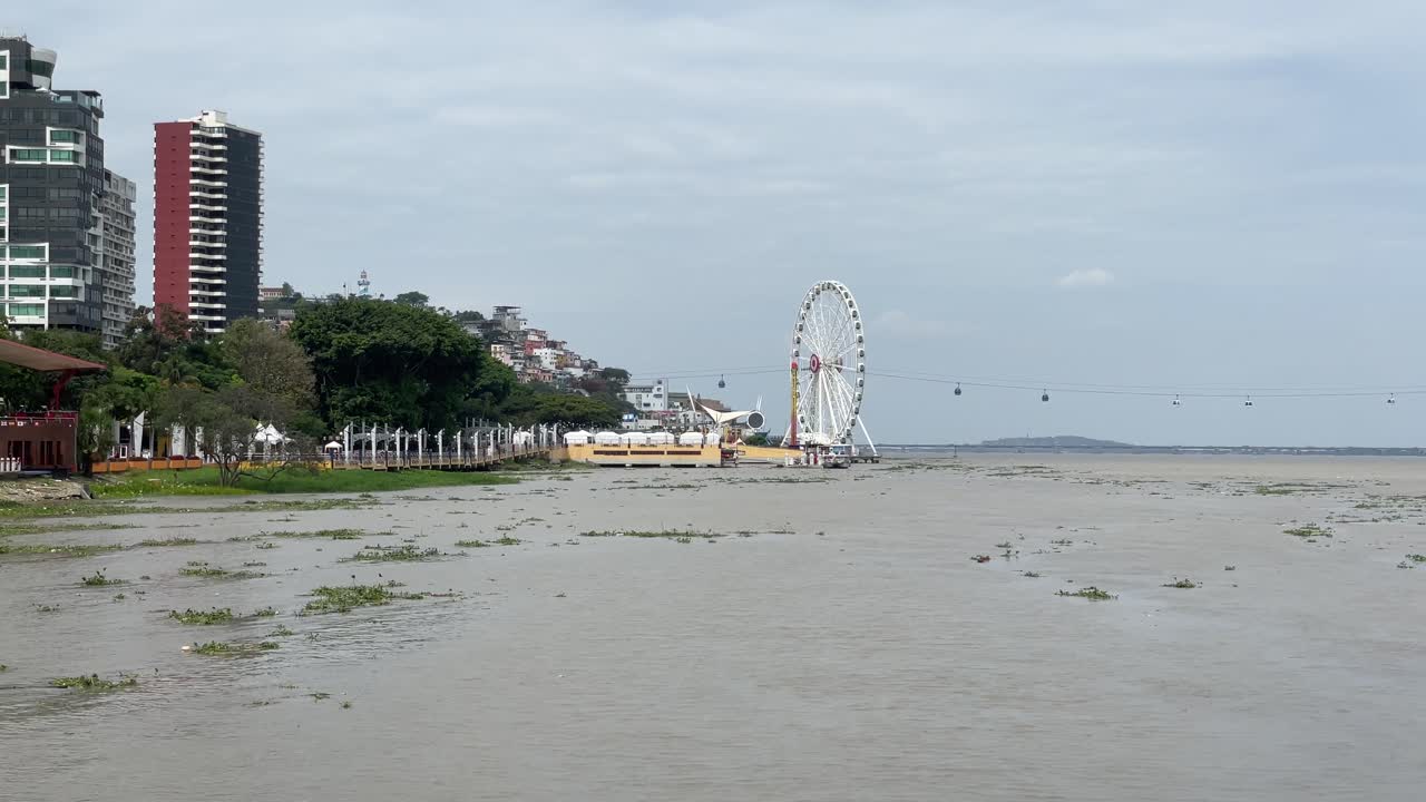 Una vista del Malecon Simon Bolivar, del fiume Guayas, della ruota panoramica La Perla e dell'Aerovia in una giornata nuvolosa