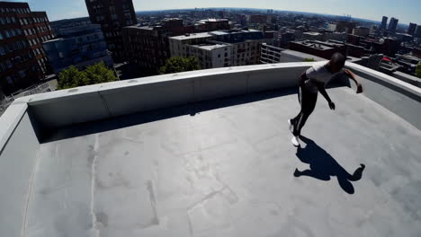 man dancing and moving on a city rooftop