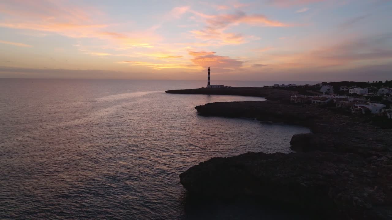 drone puesta de sol aérea brillando en la playa de la isla de menorca paisaje gradiente rosa fondo faro en destino de viaje español