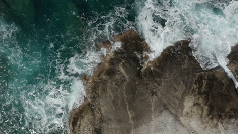 Antena-Aérea-De-Arriba-Hacia-Abajo-Vista-A-Vuelo-De-Pájaro-De-Las-Olas-Del-Océano-Rompiendo-En-Las-Rocas