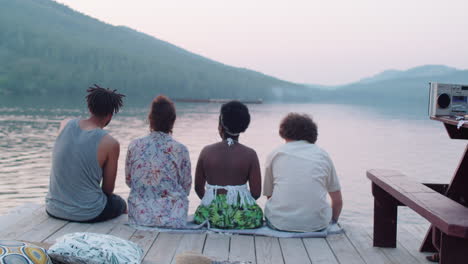 friends discussing scenic view from lake pier