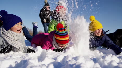 happy children and adults playing in the snow on a sunny winter day