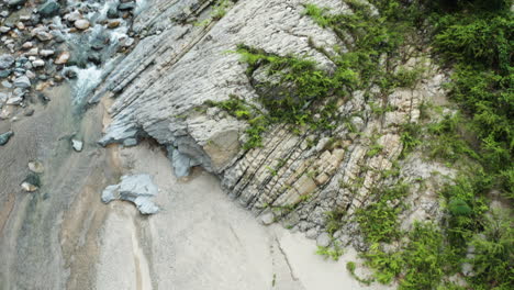 rocky rivershore with forested mountains at charcos de