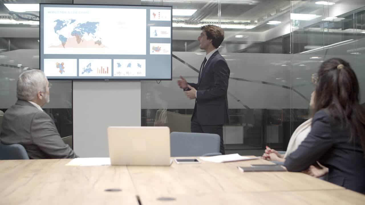 hombre seguro hablando mientras estaba de pie cerca de la pantalla con información