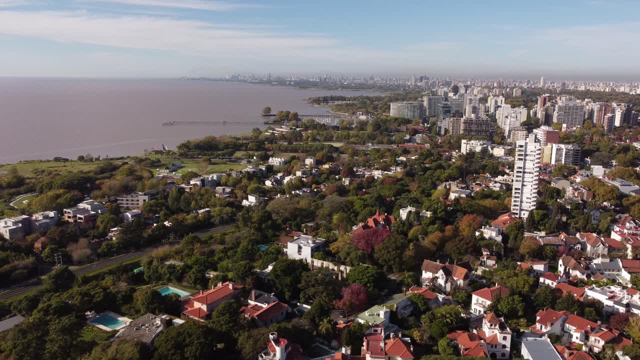 sobrevuelo aéreo zona residencial de san isidro en buenos aires con árboles y río en segundo plano durante el día soleado, 4k