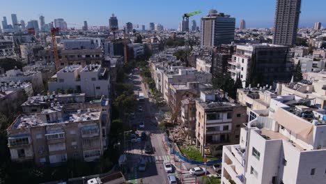 Aerial-view-of-a-bustling-city-street-with-mixed-architecture-and-highrise-buildings-in-the-background