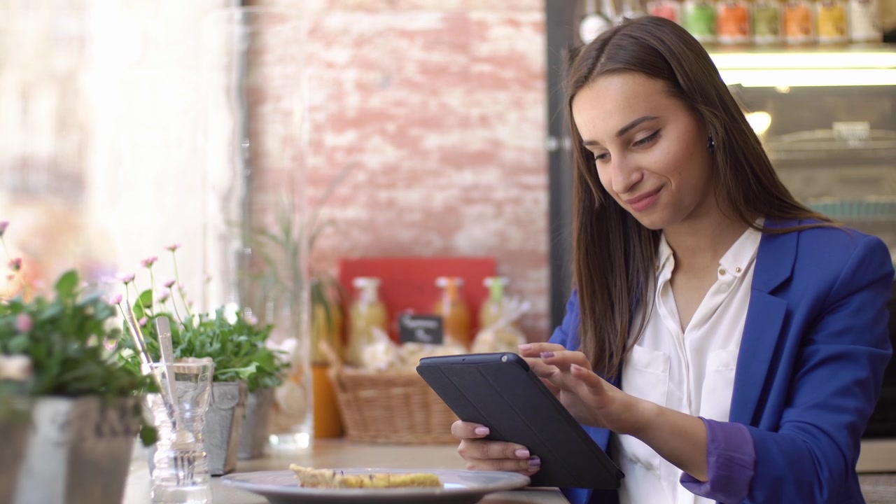 Young Woman Using Digital Tablet in a Cafe