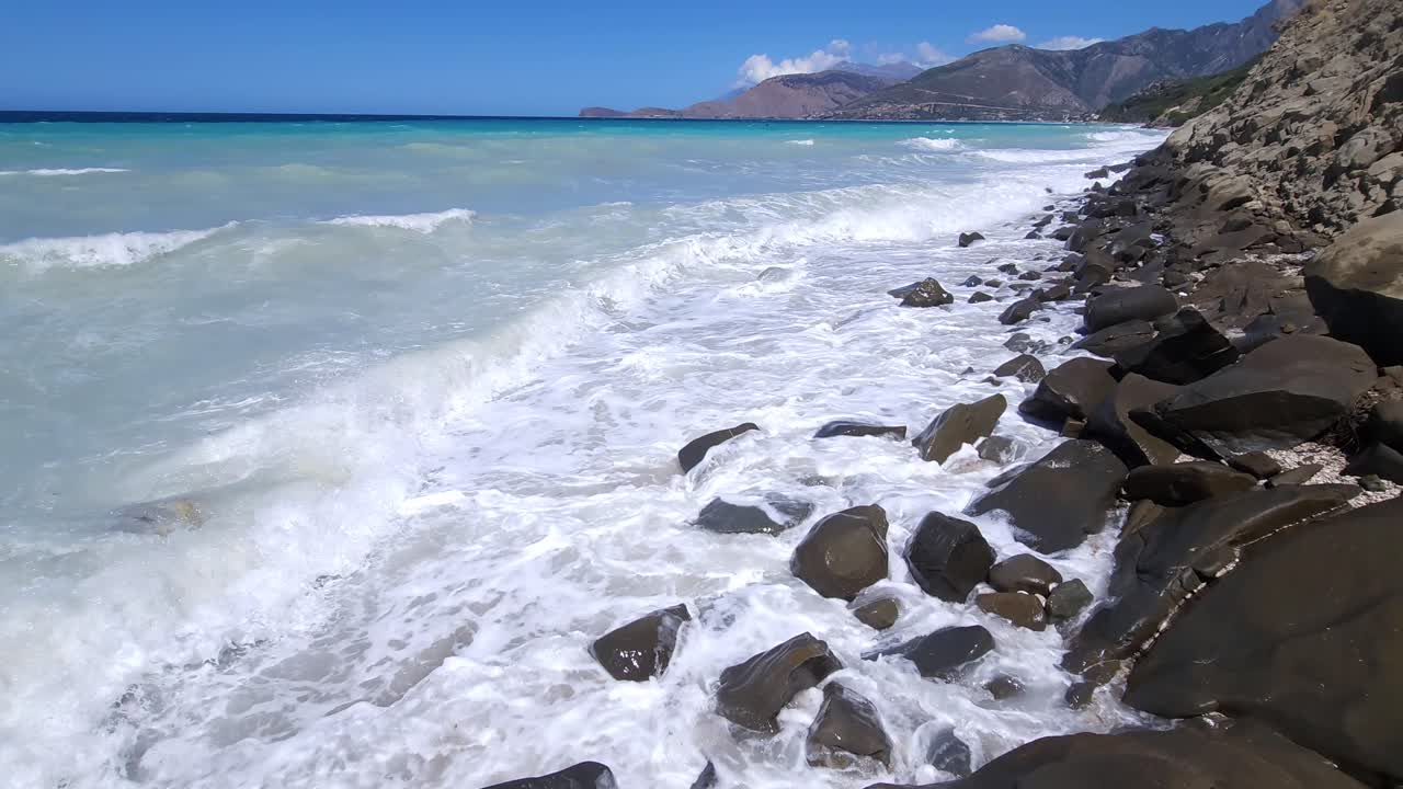 las duras olas del mar: espuma blanca en la costa rocosa en medio del hermoso panorama salvaje del azul azul y el blanco mar mediterráneo