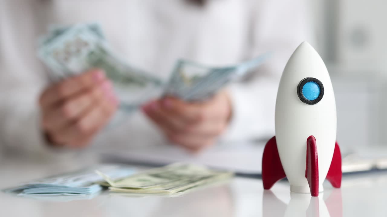 mujer de negocios cuenta con dinero personal contra el fondo de cohetes
