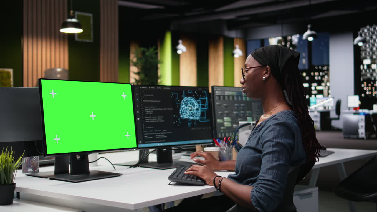 Woman Working on Computer with Green Screen Monitor in Office