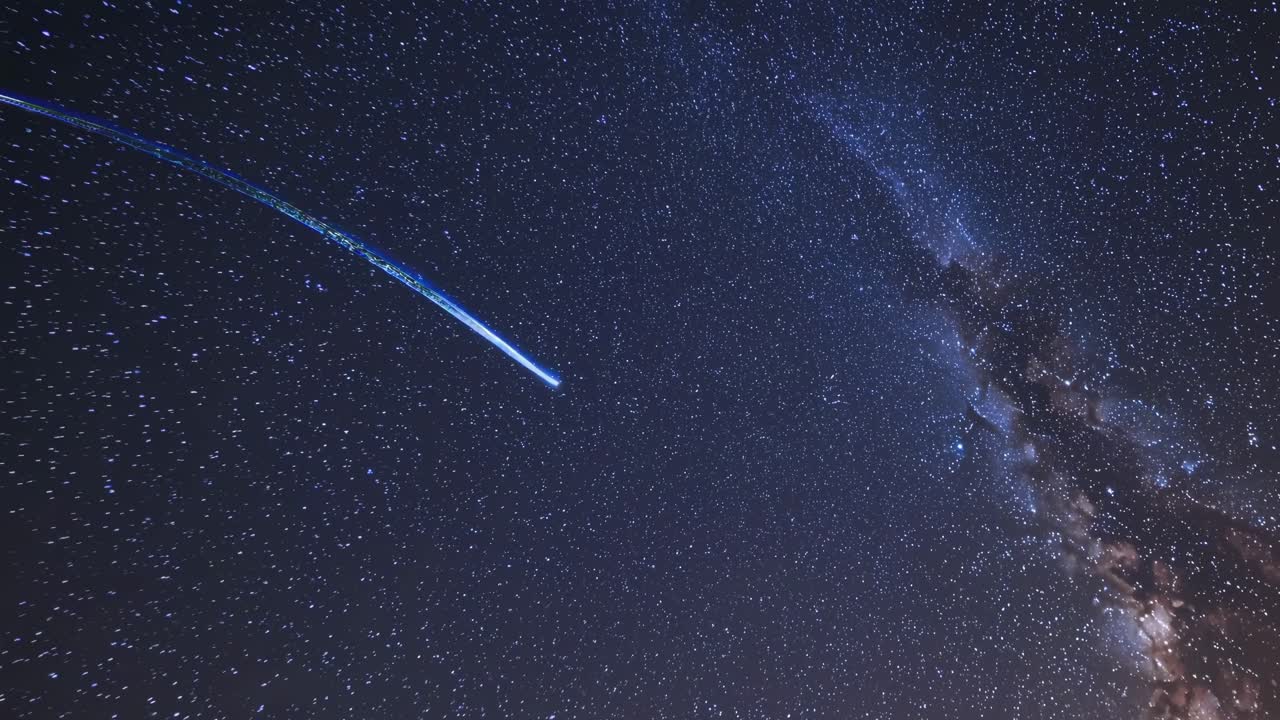 A mesmerizing night sky video with a wide-angle view captures a shooting star streaking