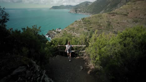 Tourist-With-Backpack-On-The-Hiking-Trail-Overlooking-Manarola-Vineyards-On-The-Italian-Coast