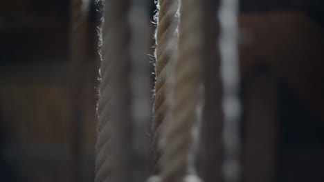 vertical ropes being pulled inside a traditional windmill