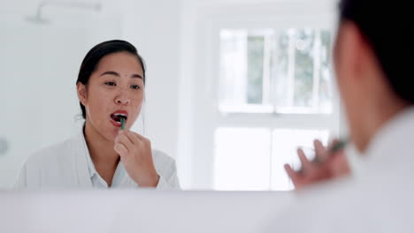 Brushing-teeth,-mirror-and-woman-in-home-bathroom