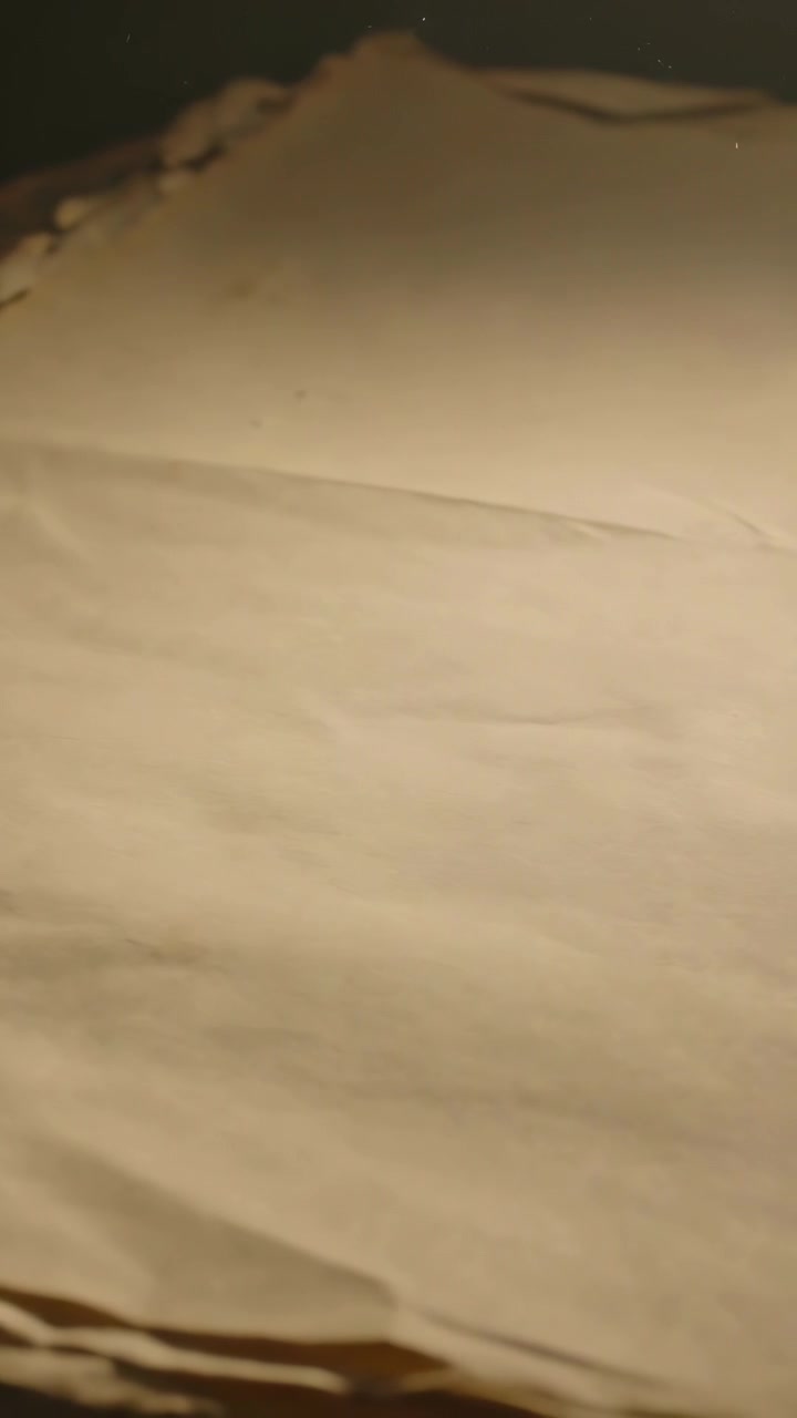 Video verticale: Telecamera a mano in panoramica su un lenzuolo beige sul letto che mostra frange e un plaid fantasia
