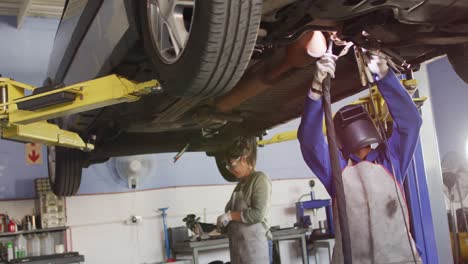 Video-of-two-diverse-female-car-mechanics-welding-car