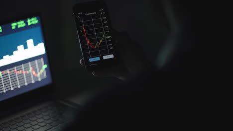 un inversor chequeando los datos del mercado de valores en la pantalla de un teléfono móvil. un hombre analizando el mercado de valores en un teléfono inteligente.