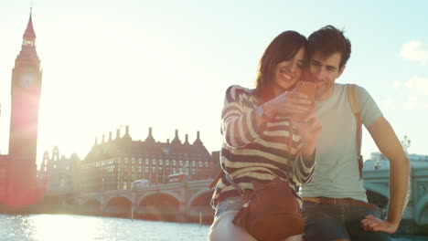 happy couple looking at a cellphone on holiday