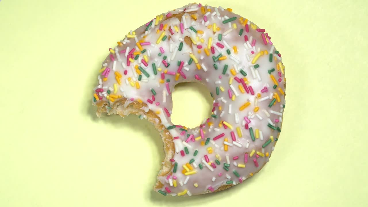 Deliziosa ciambella dolce che gira su sfondo colorato
