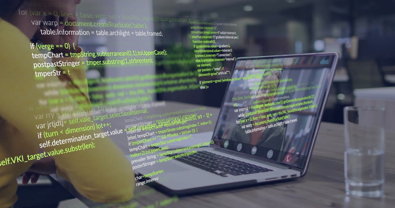Woman sitting at desk during call green code overlaying laptop screen and arm highlighting IT risk