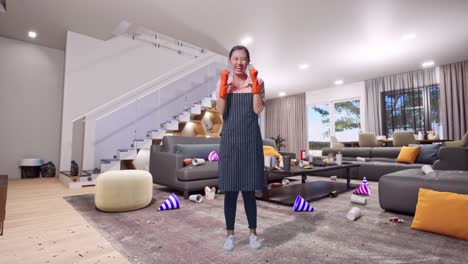 cuerpo lleno de feliz ama de casa asiática con un delantal celebrando mientras está de pie en la casa