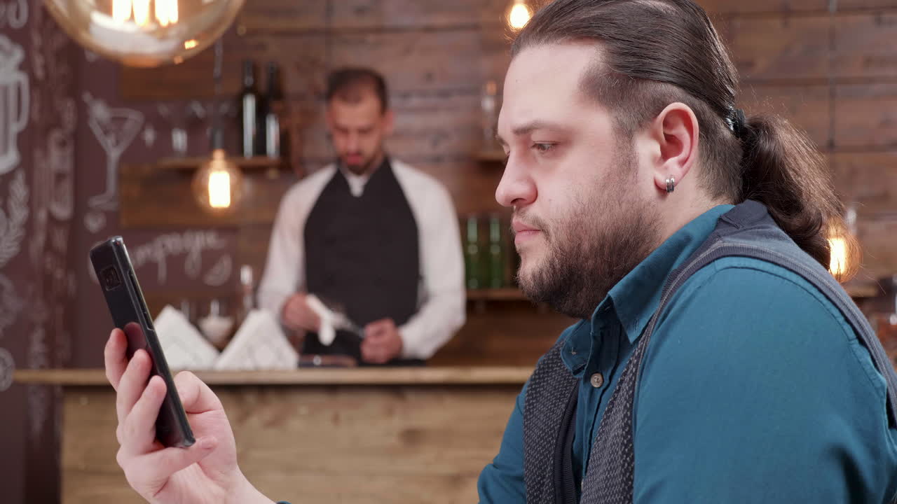 Man using smartphone at the bar