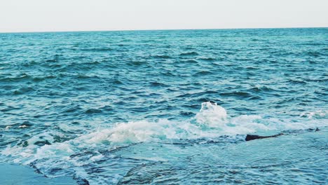 crests of the waves are breaking on the reefs near the shore in the summer. seascape. slow motion. aerial view