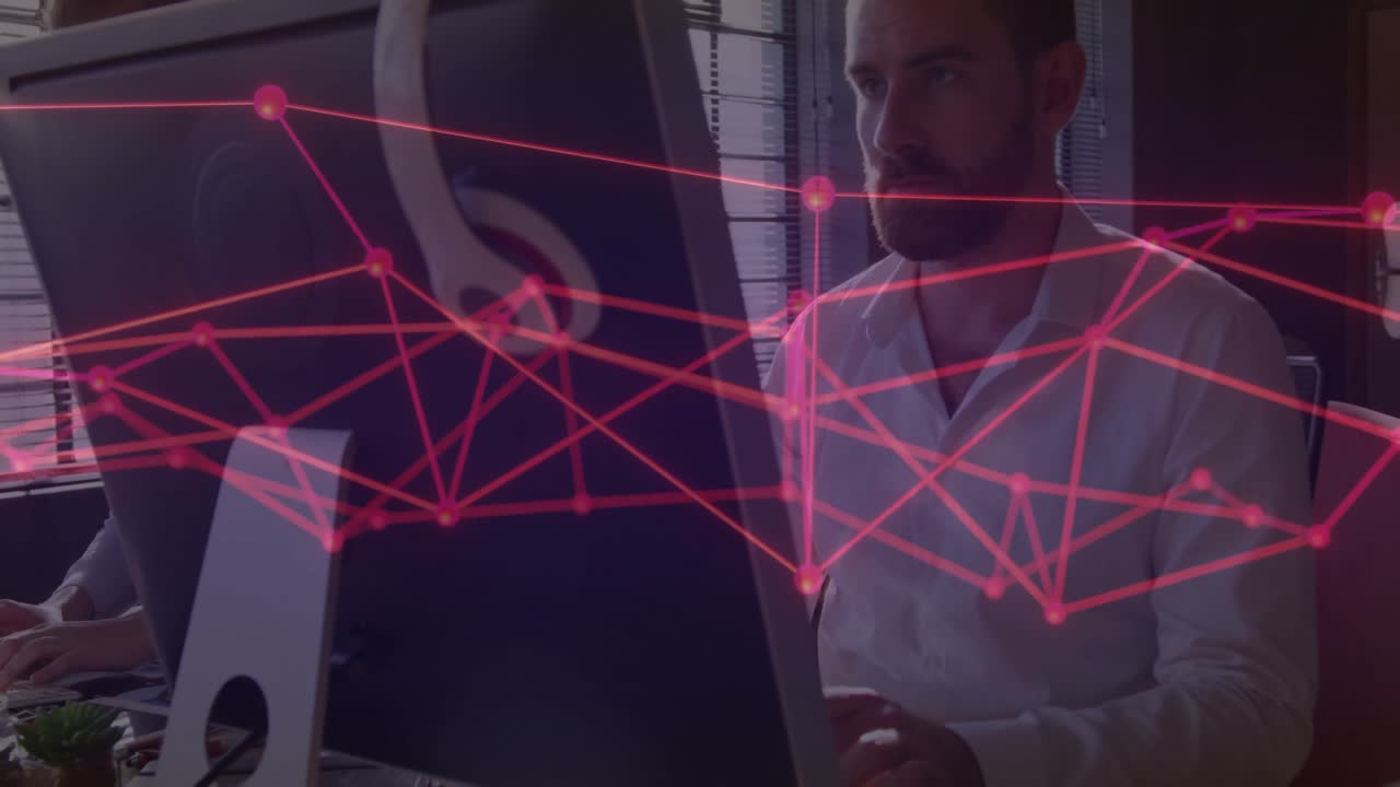 Senior office worker typing on keyboard and activating red network overlay for data monitoring