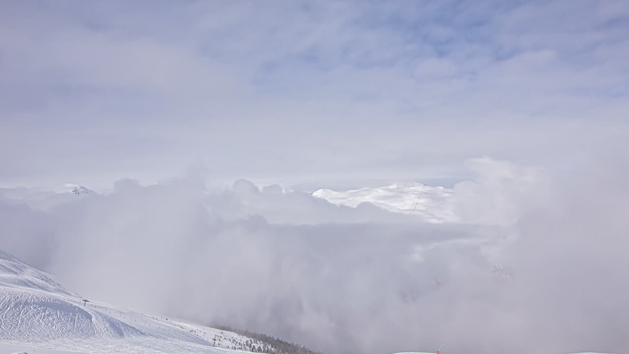 巨大な吹雪と雲が山頂に上る