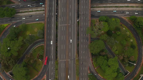 Aerial-ascending-birds-eye-close-up-overhead-top-down-view-of-multiple-vehicles-on-a-multi-lane-road-intersection-on-a-highway