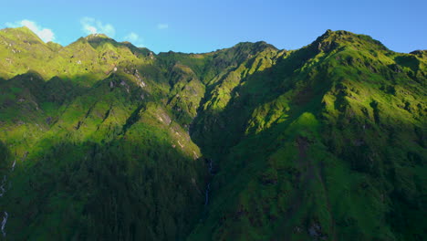 green hills shadow of clouds with sunrays in nepal, landscape with waterfall in middle