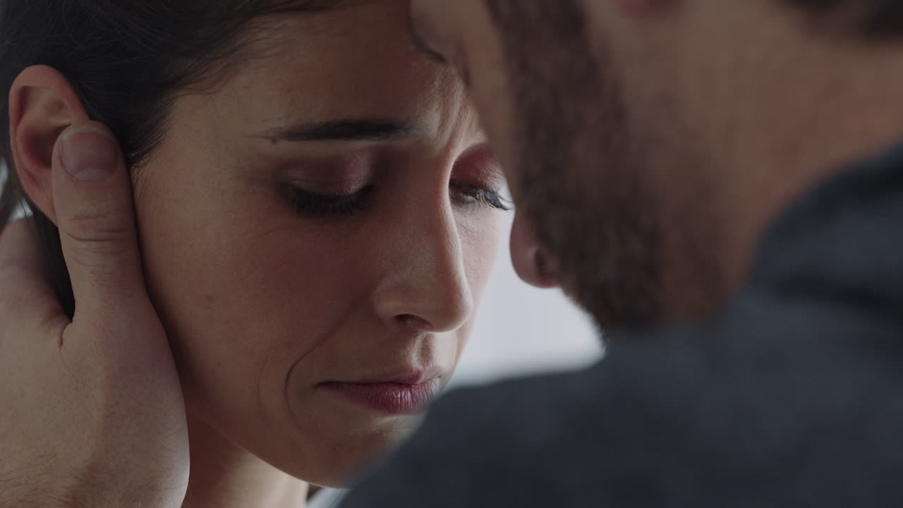 불행한 커플의 관계에 문제가 있습니다. 남자가 여자 얼굴을 만지고, 애정을 보여줍니다.