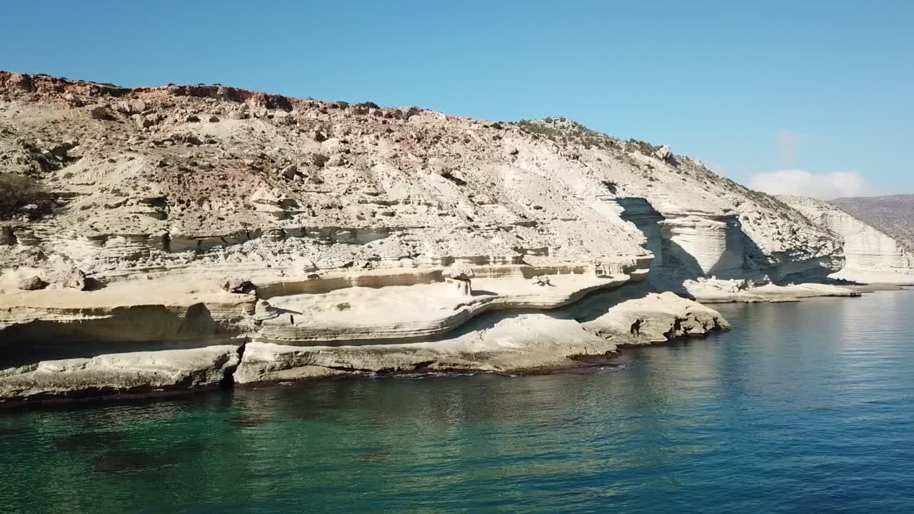 Close-up drone shot of a traditional Moroccan mosque minaret overlooking the city of Nador and the calm waters of Mar Chica lagoon